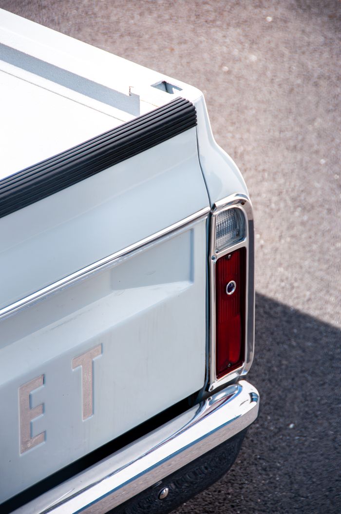 services-01 Detail of a classic Chevrolet truck's tail light and bumper, showcasing vintage automotive design.